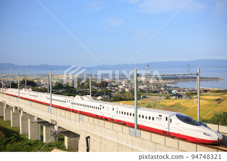 Shinkansen "Kamome" heading for Takeo Onsen with Omura Bay in the background (JR Kyushu West Kyushu Shinkansen) 94748321