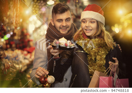 Joyful young couple in Christmas hat delighted with purchases 94748818