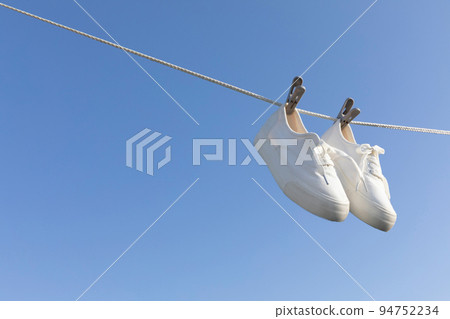 aesthetic laundry concept_sneakers hung on a clothesline 94752234
