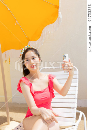 summer vacation concept_korean beautiful asian young woman taking a selfie sitting on the sunbed summer vacation concept_korean beautiful asian young woman taking a selfie sitting on the sunbed 94753288