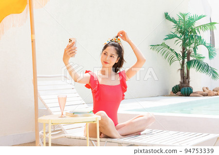 summer vacation concept_korean beautiful asian young woman taking a selfie sitting on the sunbed 94753339