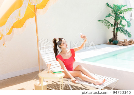 summer vacation concept_korean beautiful asian young woman taking a selfie sitting on the sunbed 94753340