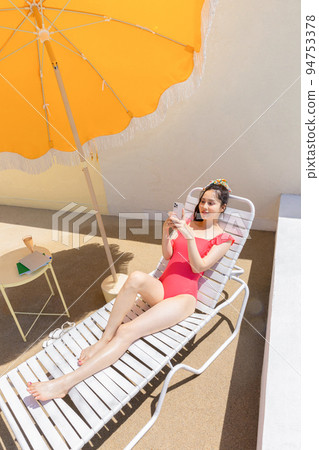 summer vacation concept_korean beautiful asian young woman using smartphone lying on the sunbed summer vacation concept_korean beautiful asian young woman using smartphone lying on the sunbed 94753378