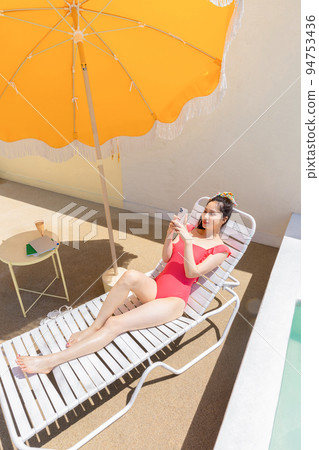 summer vacation concept_korean beautiful asian young woman taking as selfie lying on the sunbed summer vacation concept_korean beautiful asian young woman taking as selfie lying on the sunbed 94753436