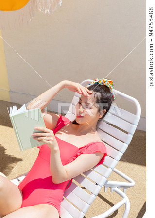 summer vacation concept_korean beautiful asian young woman reading a book lying on the sunbed summer vacation concept_korean beautiful asian young woman reading a book lying on the sunbed 94753488