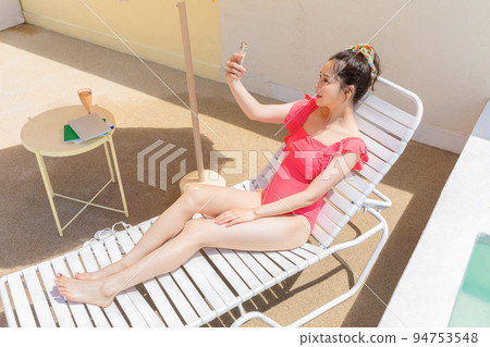 summer vacation concept_korean beautiful asian young woman taking a selfie sitting on the sunbed summer vacation concept_korean beautiful asian young woman taking a selfie sitting on the sunbed 94753548