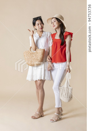 summer vacation trip with friends concept series_korean beautiful asian young women walking while pointing at the direction 94753736