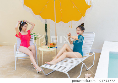 summer vacation trip with friends concept series_korean beautiful asian young women taking a rest on the sunbed 94753772