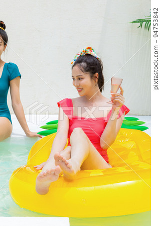 summer vacation trip with friends concept series_korean beautiful asian young women sitting on pool floats and playing on the water 94753842