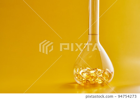 Omega-3 fatty acid capsules on a blue background in a flask. The concept of medicine and healthy living. Front view. 94754273