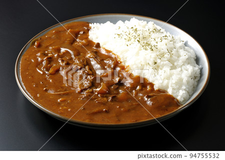 Hayashi rice with waves of sauce shot against a black background Hayashi rice with waves of sauce shot against a black background 94755532