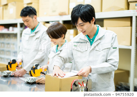 Young male staff doing packing work in the backyard Young male staff doing packing work in the backyard 94755920