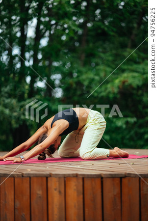 A young woman in doing yoga in the yard 94756225