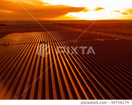 Aerial top view of a solar panels power plant. Photovoltaic solar panels at sunrise and sunset in countryside from above. Modern technology, climate care, earth saving, renewable energy concept. Aerial top view of a solar panels power plant. Photovoltaic solar panels at sunrise and sunset in countryside from above. Modern technology, climate care, earth saving, renewable energy concept. 94756274