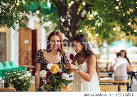 Two young women make up a beautiful festive bouquet. 94756291