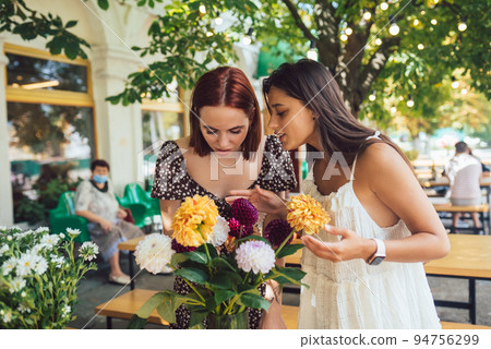 Two young women make up a beautiful festive bouquet. 94756299