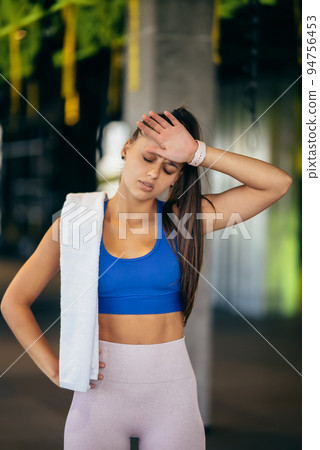 Healthy young female relaxed after training in gym. 94756453