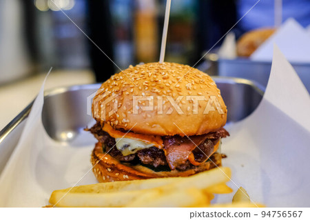 Beef burger with french fries in the restaurant. Beef burger with french fries in the restaurant. 94756567