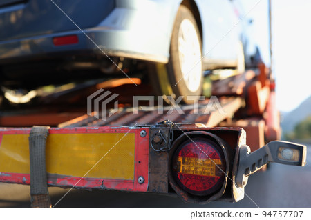 Broken car is being loaded by tow truck 94757707