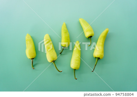 green peppers on the green background 94758804