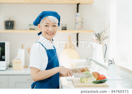 Housekeeper senior woman cooking in the kitchen Housekeeper senior woman cooking in the kitchen 94760571