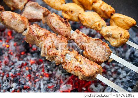 Pork and chicken skewers are fried on skewers on the grill 94761092