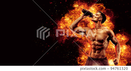 Muscular man with protein drink in shaker over dark background with fire flames 94761320