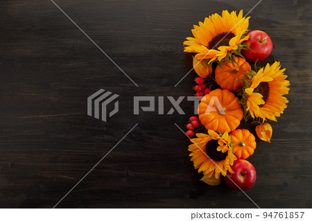 Pumpkin and sunflowers over old wooden background with copy space. Autumn background decoration. 94761857