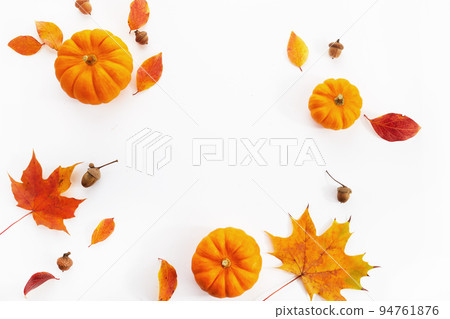 Pumpkins with fall leaves over white background. Top view. Pumpkins with fall leaves over white background. Top view. 94761876