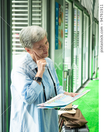 60 Many-year-old hand-held travel destination map of mature Asian women portrait, travel, travel or tourism exploration concepts. 94761911