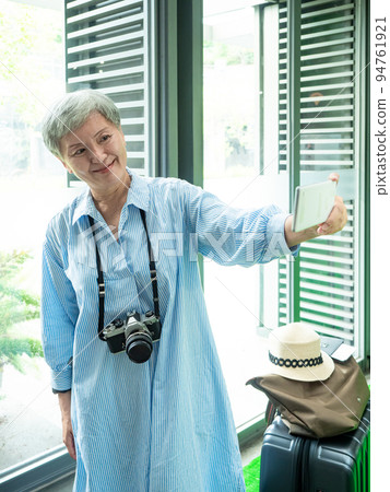 一位 60 歲的成熟亞洲女性寫下智慧型的自我打擊、旅行或觀光探索概念。 一位 60 歲的成熟亞洲女性寫下智慧型的自我打擊、旅行或觀光探索概念。 94761921