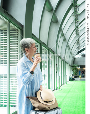一位 60 歲的亞洲成熟女性戴著紙杯喝茶或喝咖啡,等待旅行或觀光的概念。 一位 60 歲的亞洲成熟女性戴著紙杯喝茶或喝咖啡,等待旅行或觀光的概念。 94761964