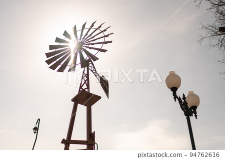 old wind turbine with blades on cloudy sky background old wind turbine with blades on cloudy sky background 94762616