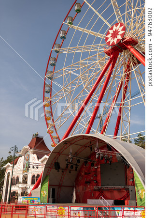 Round ferris wheel spins fast at colorful day 94763002