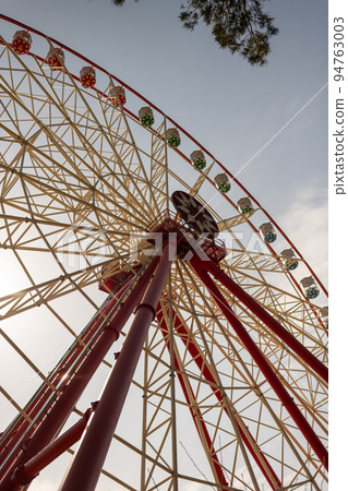 Round ferris wheel spins fast at colorful day 94763003