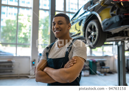 Pleased African American car technician in the workplace 94763158