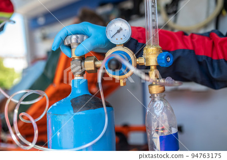 Experienced ambulance doctor preparing the medical equipment for oxygen therapy 94763175