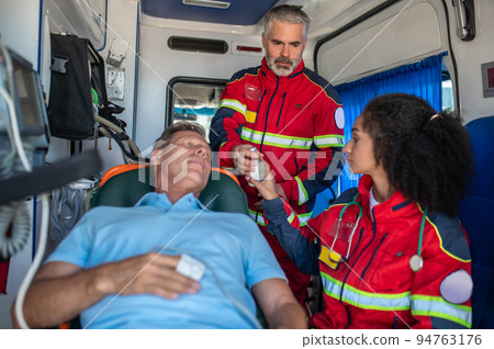 Paramedical personnel getting the man ready for the IV drip Paramedical personnel getting the man ready for the IV drip 94763176