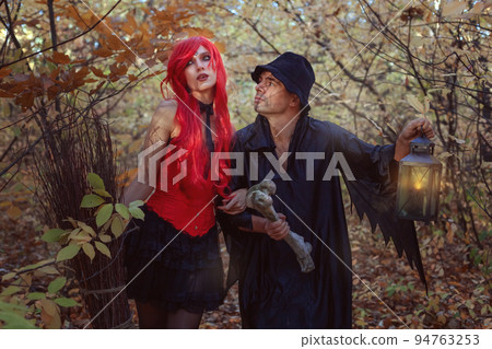 Beautiful witch and dwarf in the autumn forest. 94763253