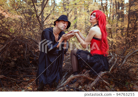 Beautiful witch and dwarf in the autumn forest. 94763255