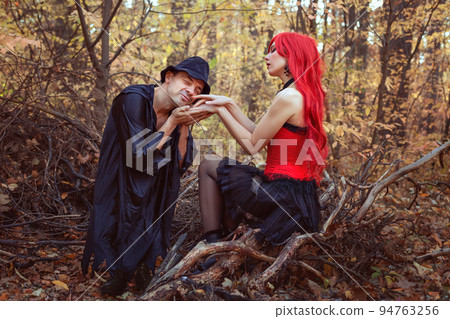 Beautiful witch and dwarf in the autumn forest. Beautiful witch and dwarf in the autumn forest. 94763256