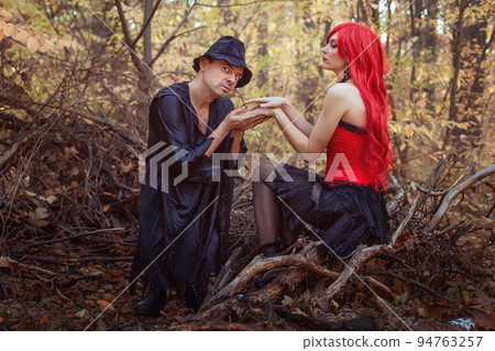 Beautiful witch and dwarf in the autumn forest. Beautiful witch and dwarf in the autumn forest. 94763257
