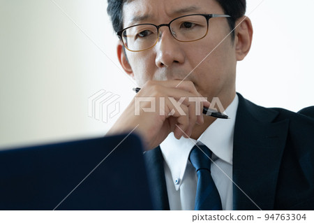 Businessman worried about looking at laptop Businessman worried about looking at laptop 94763304