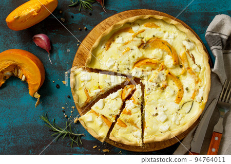 Classic Quiche Lorraine Pie with Pumpkin and Feta Cheese on blue concrete or stone table. Top view flat lay background. Classic Quiche Lorraine Pie with Pumpkin and Feta Cheese on blue concrete or stone table. Top view flat lay background. 94764011