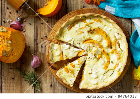Classic Quiche Lorraine Pie with Pumpkin and Feta Cheese on a wooden table. Top view flat lay background. 94764018