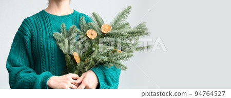Women's holding Christmas spruce branches for make decoration. 94764527
