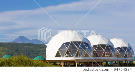 Glamping house and volcano, rural landscape, tent houses in Kamchatka peninsula. Selective focus. 94764884