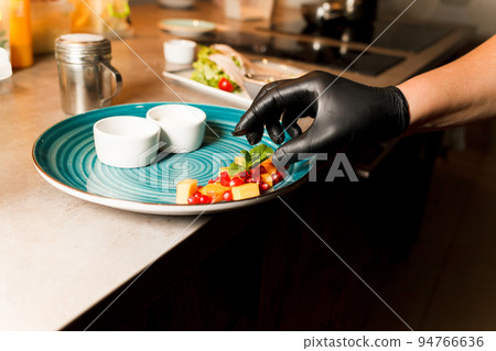 Chef preparing home made cottage cheese fried in a pan and served with sauces and fruit.. Chef preparing home made cottage cheese fried in a pan and served with sauces and fruit.. 94766636