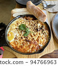Meat sauce and cheese grilled on a hot iron plate with bread 94766963
