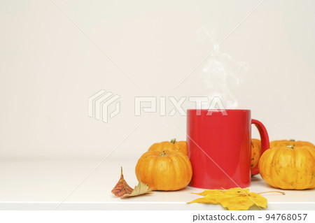 A cup of hot autumn drink coffee or tea with pumpkins and fall decor on an empty white background. A cup of hot autumn drink coffee or tea with pumpkins and fall decor on an empty white background. 94768057
